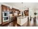 Gourmet kitchen boasts dark wood cabinetry, granite countertops, a wine cooler, and stainless steel appliances at 9182 Ridgegate Pkwy, Lone Tree, CO 80124