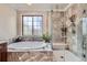 Spa-like bathroom features a soaking tub, a walk-in shower, and modern fixtures at 9182 Ridgegate Pkwy, Lone Tree, CO 80124