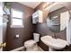 Well-lit powder room features a pedestal sink, round mirror, and decorative wall shelves at 1941 Fox Fire St, Highlands Ranch, CO 80129