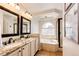 Bright bathroom featuring double sinks, granite counters, soaking tub, and glass enclosed shower at 1941 Fox Fire St, Highlands Ranch, CO 80129