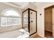 Bathroom showcasing separate glass enclosed shower and soaking tub under a glass block window at 1941 Fox Fire St, Highlands Ranch, CO 80129