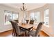 Cozy dining room features hardwood floors, multiple windows, and stylish chandelier for elegant meals at 1941 Fox Fire St, Highlands Ranch, CO 80129