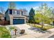 Charming two-story home boasts a blue exterior, stone accents, well-manicured lawn, and a blue garage door at 1941 Fox Fire St, Highlands Ranch, CO 80129