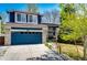 Charming two-story home boasts a blue exterior, stone accents, well-manicured lawn, and a blue garage door at 1941 Fox Fire St, Highlands Ranch, CO 80129