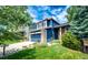Beautiful home showcasing a well-maintained lawn, blue siding, stone accents, and a convenient two-car garage at 1941 Fox Fire St, Highlands Ranch, CO 80129