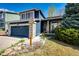 Charming home with stone accents, a blue garage door, and a well-manicured lawn at 1941 Fox Fire St, Highlands Ranch, CO 80129