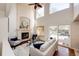 Bright living room features a fireplace, tall windows, hardwood floors, and sliding glass doors to the deck at 1941 Fox Fire St, Highlands Ranch, CO 80129