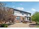 Charming back exterior of the home featuring a patio, a green lawn, and mature trees at 21434 E Greenwood Pl, Aurora, CO 80013