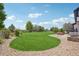 Lush backyard featuring a large grassy area, mature trees, and a decorative stone border at 21434 E Greenwood Pl, Aurora, CO 80013