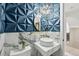 Luxurious bathroom with modern fixtures, a round mirror, and unique textured wall at 21434 E Greenwood Pl, Aurora, CO 80013