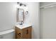 Modern bathroom with a wood vanity, framed mirror, and contemporary light fixtures at 21434 E Greenwood Pl, Aurora, CO 80013