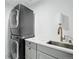 Efficient laundry room featuring a stackable washer and dryer, a marble countertop, and a modern faucet at 21434 E Greenwood Pl, Aurora, CO 80013