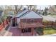 Brick patio with pergola, seating, red fencing, and brick exterior at 7785 E 13Th Ave, Denver, CO 80220