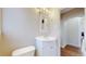Bathroom features a white corner sink with storage, wood floors, and a view into the next room at 7785 E 13Th Ave, Denver, CO 80220