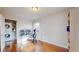 Bedroom features wood floors, a built-in shelf, and an adjacent laundry room at 7785 E 13Th Ave, Denver, CO 80220