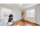 Bedroom with wood floors, two windows, a bookshelf, and a desk with a rolling office chair at 7785 E 13Th Ave, Denver, CO 80220