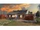 Brick home with well-maintained lawn, privacy fence, and chairs on front porch at 7785 E 13Th Ave, Denver, CO 80220