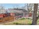 Brick home featuring well-maintained lawn, privacy fence, chairs, and a bird bath on the front patio at 7785 E 13Th Ave, Denver, CO 80220