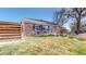 Beautiful brick home displaying well-kept lawn and appealing modern style horizontal fence, perfect for outdoor enjoyment at 7785 E 13Th Ave, Denver, CO 80220