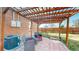 Outdoor patio area featuring a wooden pergola, brick walls, and outdoor seating furniture at 7785 E 13Th Ave, Denver, CO 80220