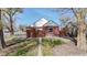 Rear exterior of a charming brick home featuring a fenced yard and wooden pergola at 7785 E 13Th Ave, Denver, CO 80220