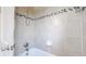 Tiled shower with decorative tile inlay, adjustable shower head, and built-in soap dish at 7785 E 13Th Ave, Denver, CO 80220
