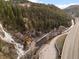 High angle aerial view of winding river near winding road and hillside, including a wooden mechanism at 2041 Virginia St, Idaho Springs, CO 80452