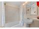 Cozy bathroom featuring a white bathtub with shower and a pedestal sink under a mirrored cabinet at 2041 Virginia St, Idaho Springs, CO 80452