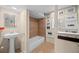 A bathroom with earth-toned tiling, featuring a bathtub and a pedestal sink against a backdrop of framed photos at 2041 Virginia St, Idaho Springs, CO 80452