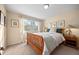 A well-lit bedroom with a wooden bed, neutral-toned walls, and a bright window framing outdoor views at 2041 Virginia St, Idaho Springs, CO 80452
