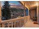 Cozy porch featuring mountain views, white railings, a sitting area, and exterior lighting at 2041 Virginia St, Idaho Springs, CO 80452