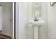 Bright half bathroom featuring a pedestal sink with a stylish faucet, white cabinets, and neutral walls at 235 Summit Cir, Lafayette, CO 80026