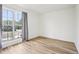 Bedroom featuring hardwood floors, white walls, and a large window with gray curtains at 235 Summit Cir, Lafayette, CO 80026