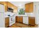 Bright kitchen features wood cabinets, white countertops, backsplash and appliances, plus a window with natural light at 235 Summit Cir, Lafayette, CO 80026