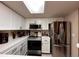 Well-lit kitchen featuring white cabinets, tile countertops, and stainless steel appliances at 4933 S Carson St # 212, Aurora, CO 80015