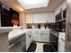 Bright kitchen with white cabinets and appliances, featuring a passthrough to the living area at 4933 S Carson St # 212, Aurora, CO 80015