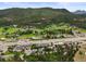 Aerial view of community with shopping area and thoroughfare nestled against the backdrop of lush mountain landscape at 26499 West St, Conifer, CO 80433