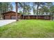 Charming wood home with a lush green lawn and a two-car attached garage surrounded by mature trees at 26499 West St, Conifer, CO 80433