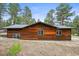 Exterior features beautiful wooden home surrounded by mature pine trees at 26499 West St, Conifer, CO 80433