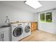 Well-lit laundry room featuring modern washer and dryer, plus wood-top cabinets at 26499 West St, Conifer, CO 80433