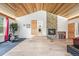 Spacious living room showcasing a stone fireplace, wood ceiling, exercise equipment and seamless flow to other spaces at 26499 West St, Conifer, CO 80433