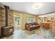 Warm and inviting living space featuring a wood-burning stove, stone floors, and rustic charm at 26499 West St, Conifer, CO 80433