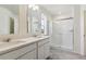 Well-lit bathroom with double vanities, white countertops, and a glass-enclosed shower at 760 N Deer Park St, Watkins, CO 80137
