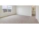 Spacious bedroom featuring plush carpet, ample natural light, and a glimpse into the attached bathroom at 760 N Deer Park St, Watkins, CO 80137