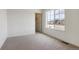 Bedroom featuring plush carpet, a window with neighborhood views, and a closet at 760 N Deer Park St, Watkins, CO 80137