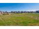 Expansive green lawn and playground in a serene community setting with lovely homes under a clear blue sky at 760 N Deer Park St, Watkins, CO 80137