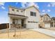 Charming two-story home featuring a stone-accented porch and an attached two-car garage at 760 N Deer Park St, Watkins, CO 80137