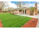 Spacious backyard featuring lush green grass, a covered patio, and wood mulch perimeter at 8487 W 62Nd Pl, Arvada, CO 80004