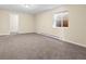 Neutral-toned carpeted basement offers flexible space, a window for light and an adjacent room at 8487 W 62Nd Pl, Arvada, CO 80004