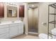 Bright bathroom featuring a white vanity, framed mirror, and a tiled stand up shower with a glass door at 8487 W 62Nd Pl, Arvada, CO 80004